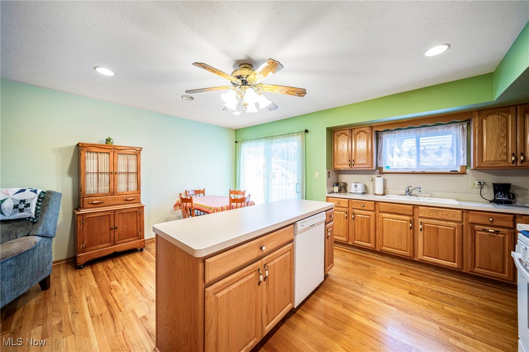 30888 Harrison Road Wickliffe, OH 44092 - Photo 10 of 33 Kitchen featuring dishwasher, a ceiling fan, light countertops, light wood finished floors, and a center island