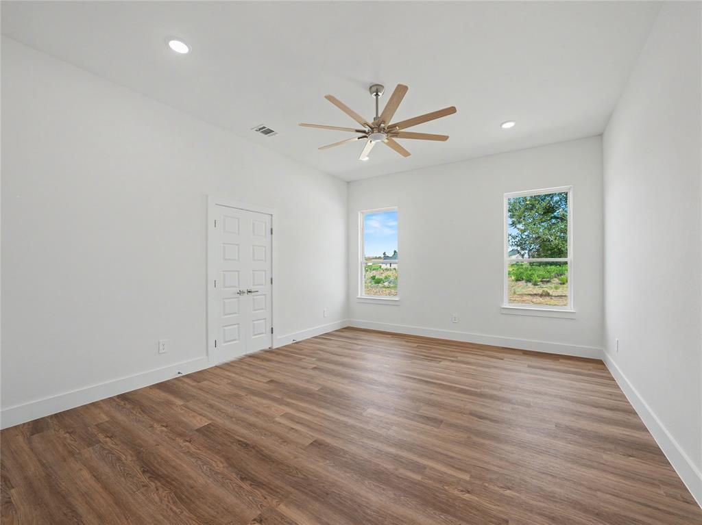 328 Slimp Bluff Azle, TX 76020 - Photo 14 of 30 Expansive room featuring wood-finish flooring, crisp white walls, and a contemporary ceiling fan