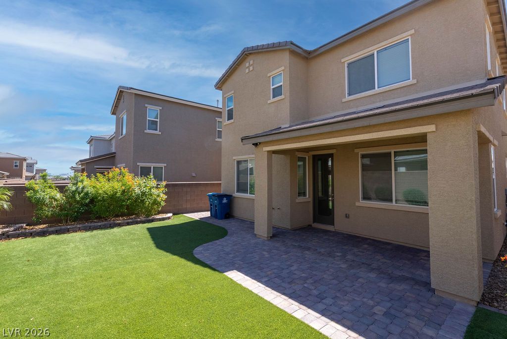 7126 Calvert Cliffs Street North Las Vegas, NV 89084 - Photo 38 of 44 A private backyard oasis features a paved patio, lush artificial turf, and mature landscaping.