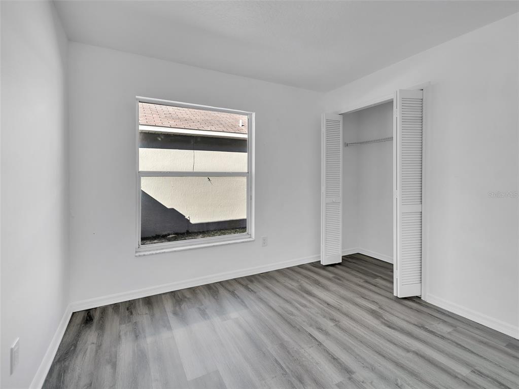 11606 Goodwyck Drive Orlando, FL 32837 - Photo 13 of 18 an empty room with wooden floor and windows