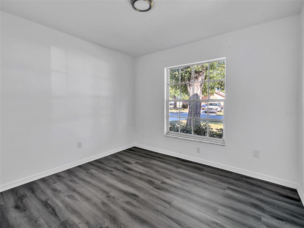 11606 Goodwyck Drive Orlando, FL 32837 - Photo 15 of 18 an empty room with wooden floor and windows