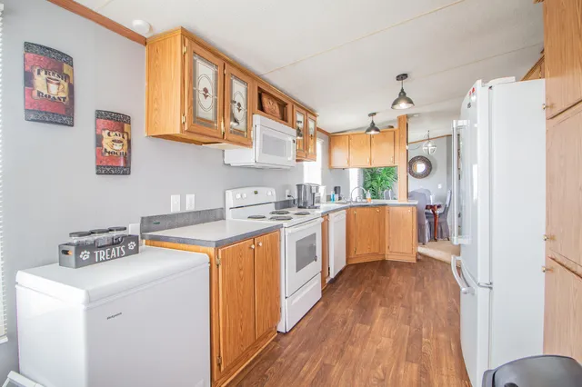 a kitchen with a refrigerator a sink and wooden floor
