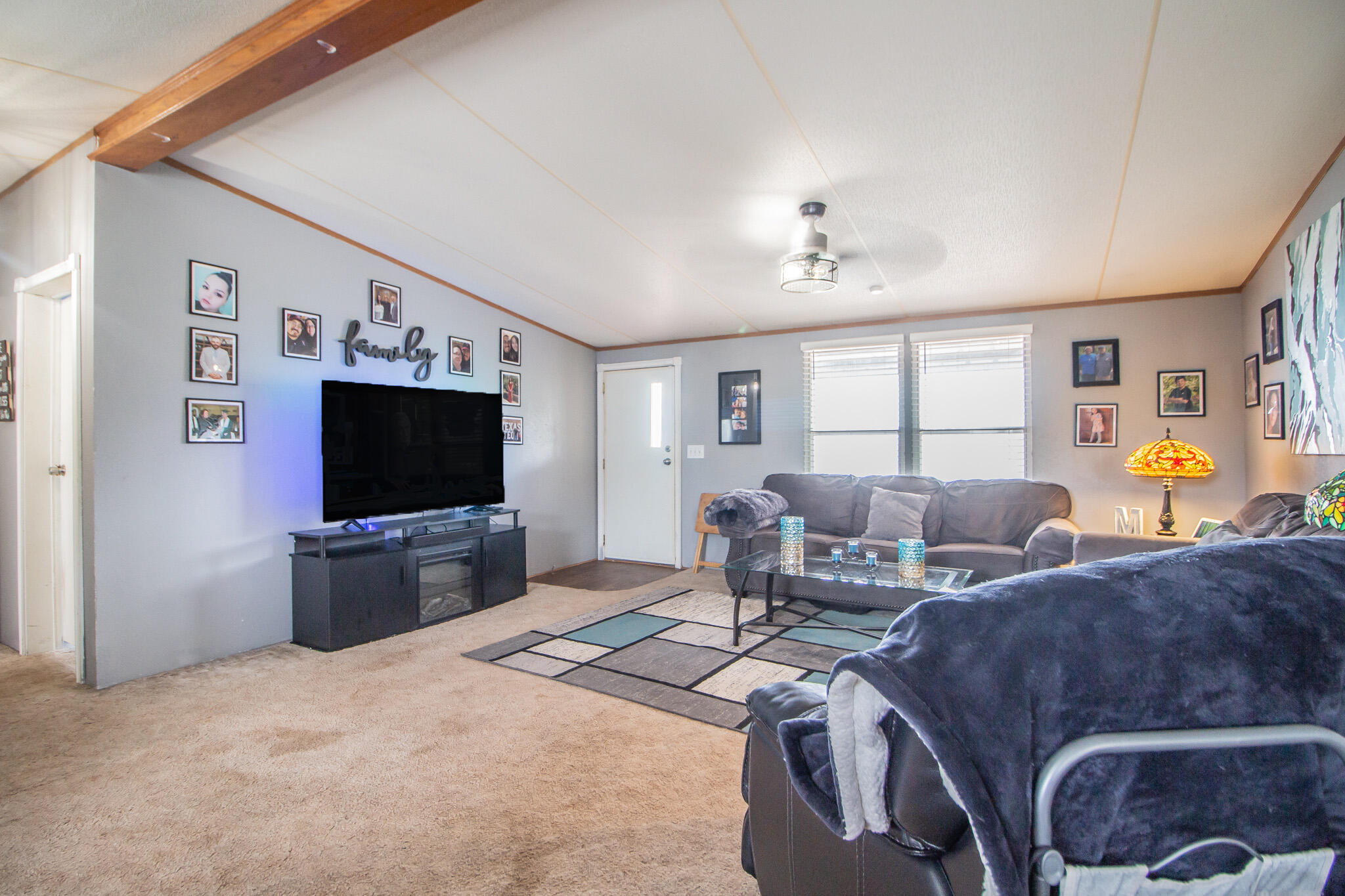 230 Bull Rider Road, Unit C Lubbock, TX 79404 - Photo 4 of 37 a living room with furniture a flat screen tv and a window