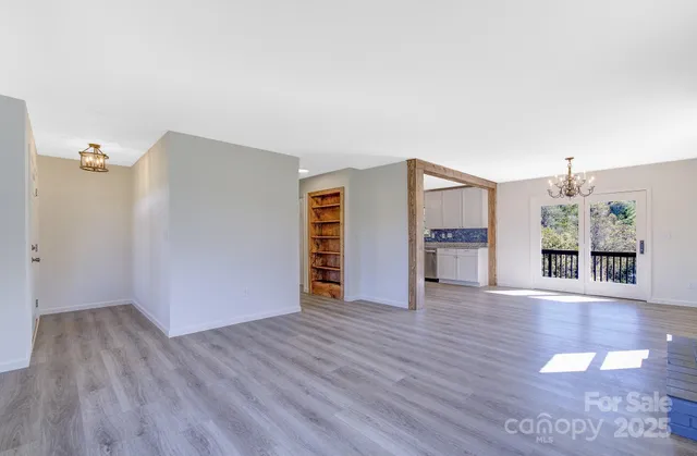 a view of a livingroom with wooden floor and a refrigerator