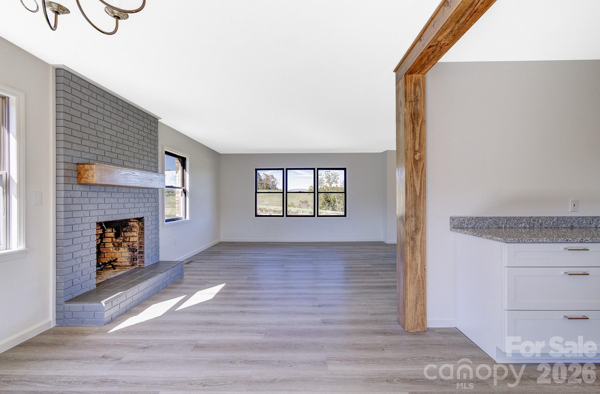1248 Jenkins Valley Road Alexander, NC 28701 - Photo 16 of 43 a view of an empty room with a fireplace and a window