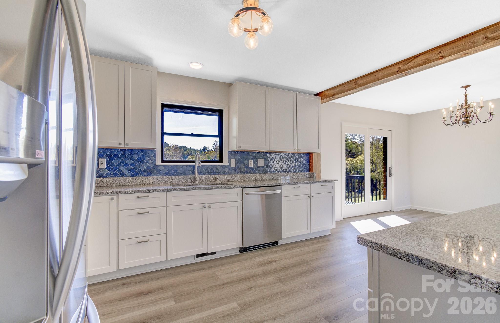 1248 Jenkins Valley Road Alexander, NC 28701 - Photo 21 of 43 a kitchen with granite countertop cabinets stainless steel appliances a sink and a window