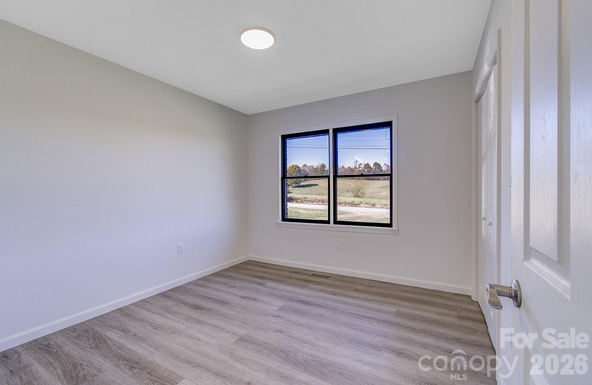 1248 Jenkins Valley Road Alexander, NC 28701 - Photo 26 of 43 an empty room with wooden floor and windows