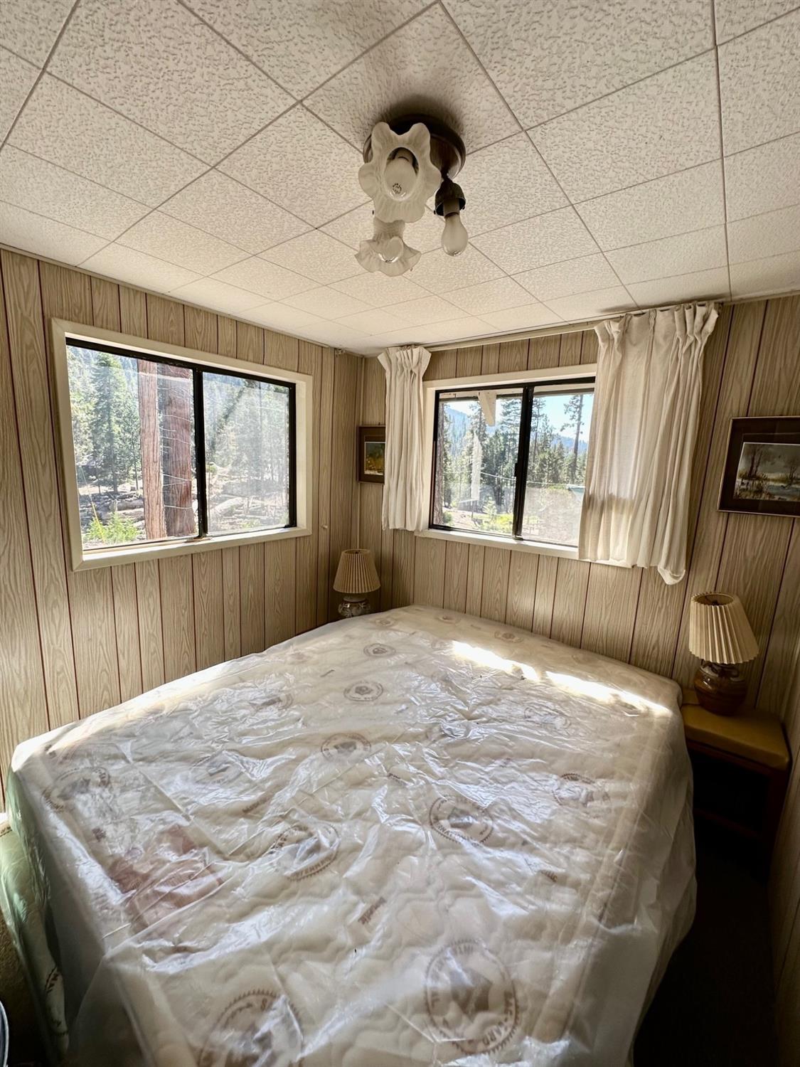 54758 Dinkey Creek Road Shaver Lake, CA 93664 - Photo 24 of 39 a bedroom with a bed and a large window