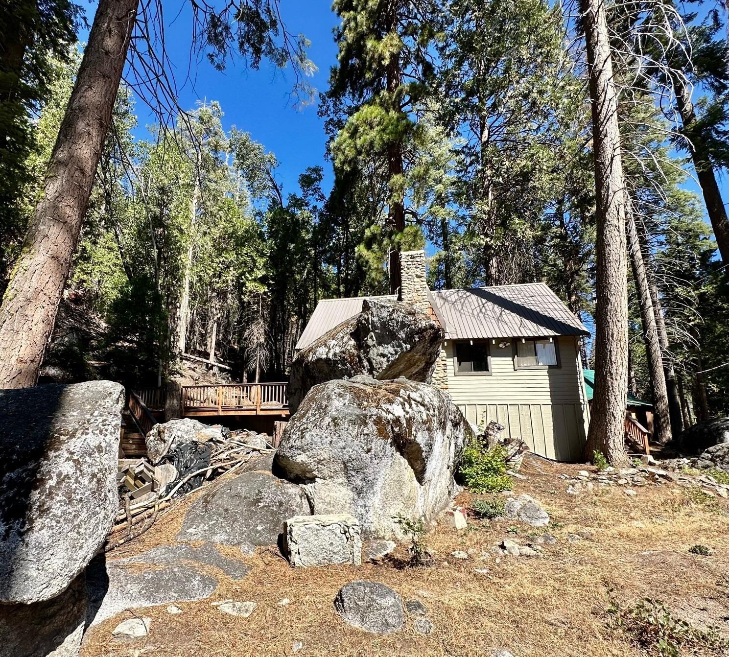 54758 Dinkey Creek Road Shaver Lake, CA 93664 - Photo 6 of 39 a view of a wooden house with a yard covered in snow