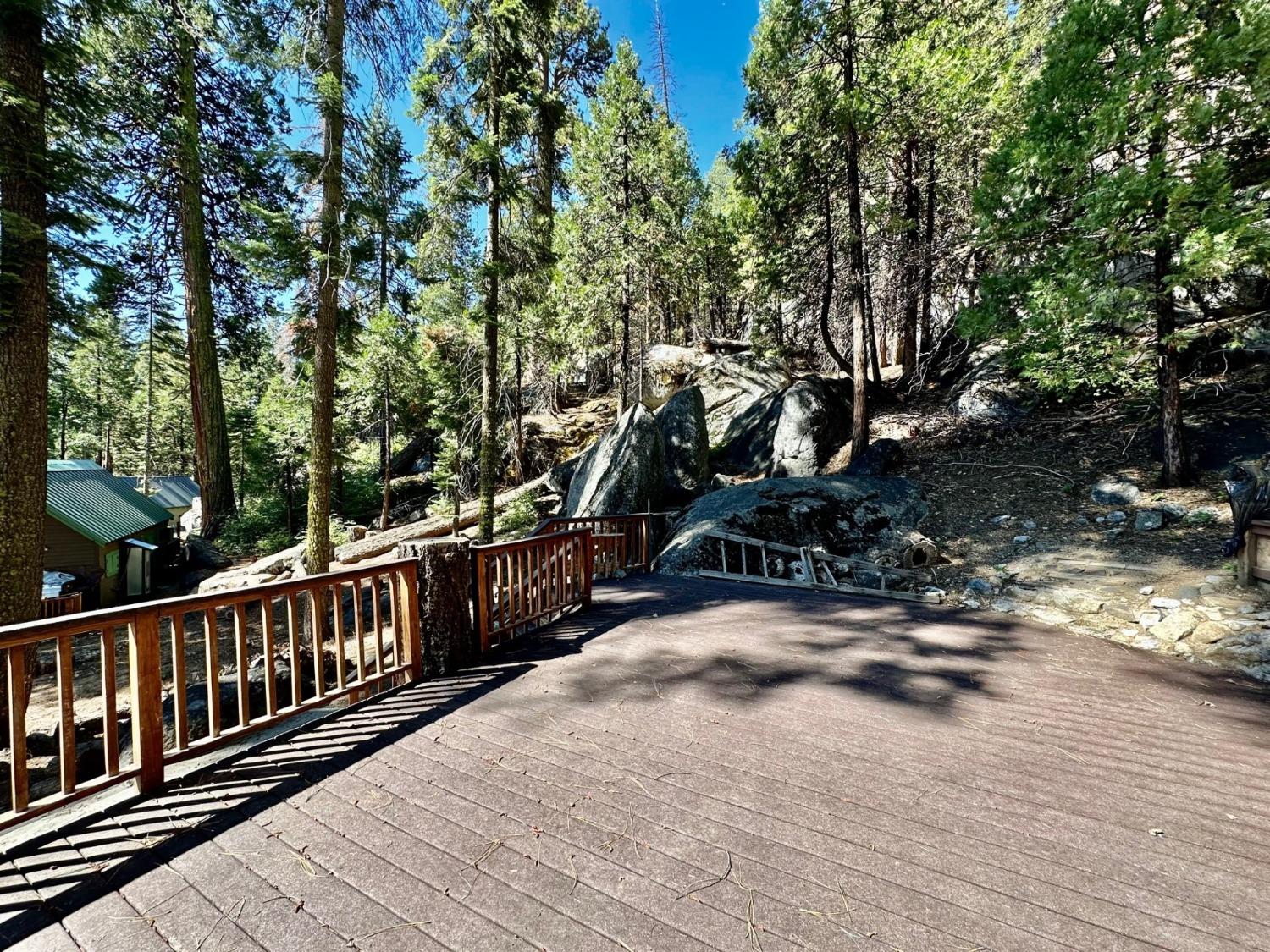 54758 Dinkey Creek Road Shaver Lake, CA 93664 - Photo 7 of 39 a view of a wooden deck next to a yard