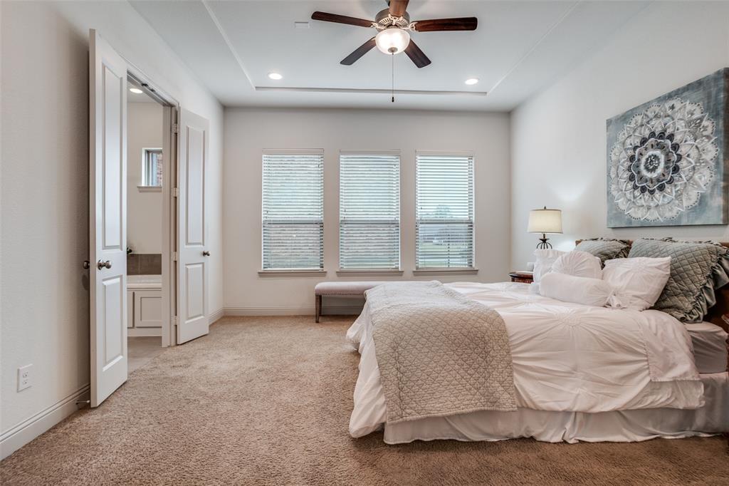 608 Arma Road Allen, TX 75002 - Photo 18 of 40 a spacious bedroom with a large bed and a chandelier