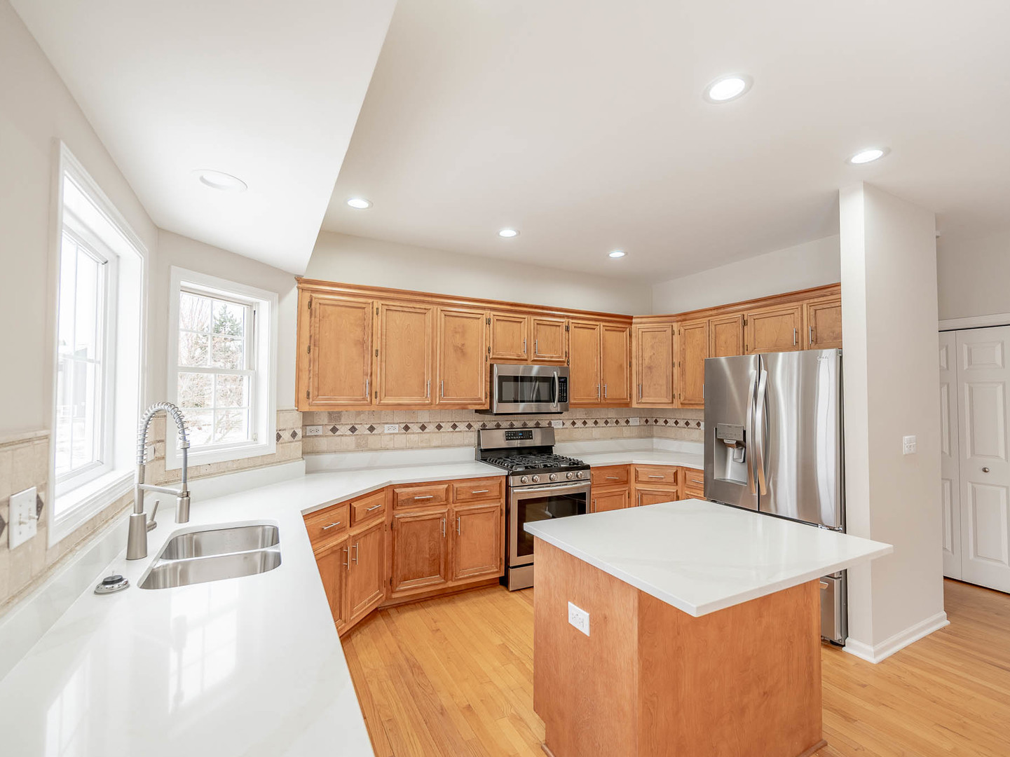975 Merbach Court Carol Stream, IL 60188 - Photo 9 of 28 a large kitchen with kitchen island a sink dishwasher a stove a refrigerator with a dining table and chairs