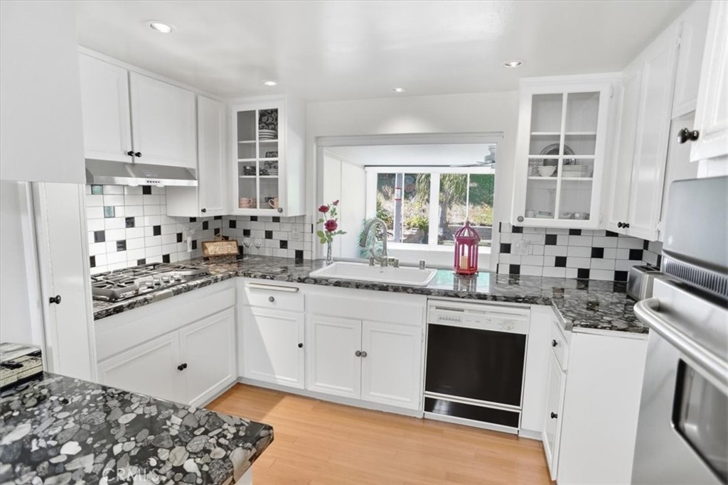 19427 Oak Crossing Road Newhall, CA 91321 - Photo 10 of 45 a kitchen with stainless steel appliances a stove a sink and white cabinets