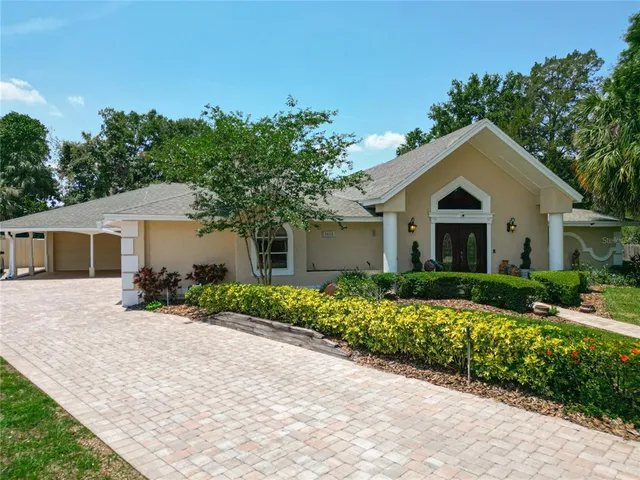 a front view of a house with a yard and potted plants