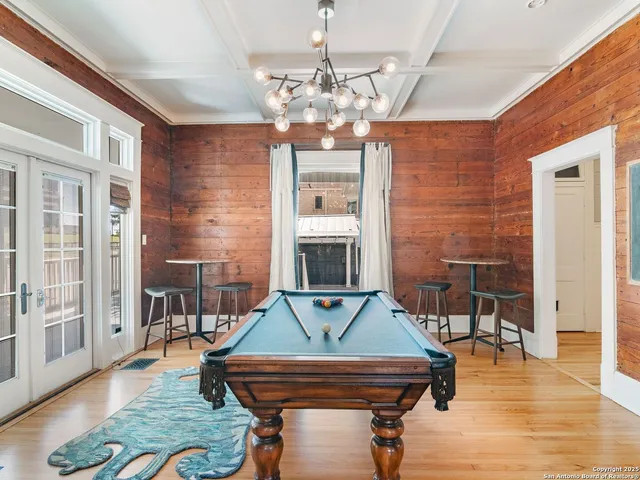 a room with pool table and windows