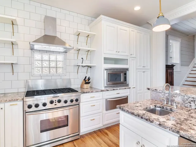 a bathroom with a granite countertop sink and a large mirror