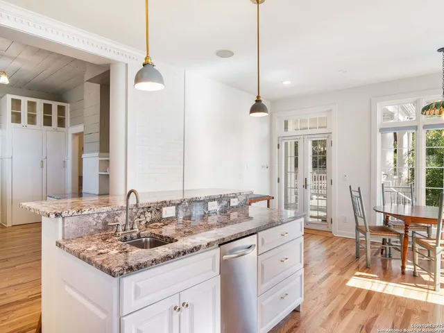 a dining room with furniture a chandelier and wooden floor