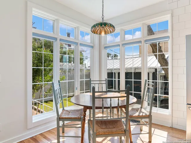 a kitchen with stainless steel appliances a dining table chairs and wooden floor
