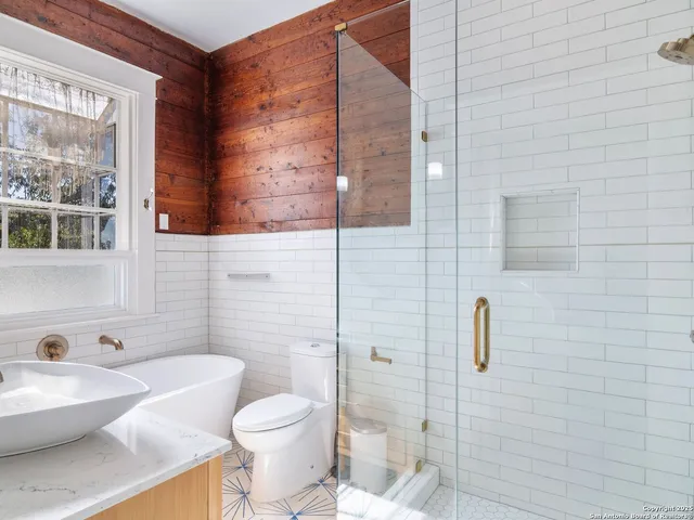 a bathroom with blue tub sitting next to a window