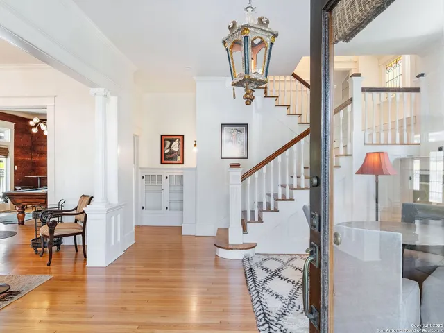 a dining room with wooden floor windows and a chandelier