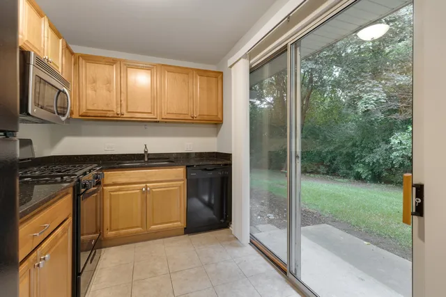 a kitchen with stainless steel appliances granite countertop a refrigerator a sink and a stove