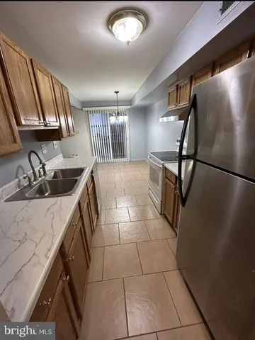 a kitchen with a sink a stove and a refrigerator