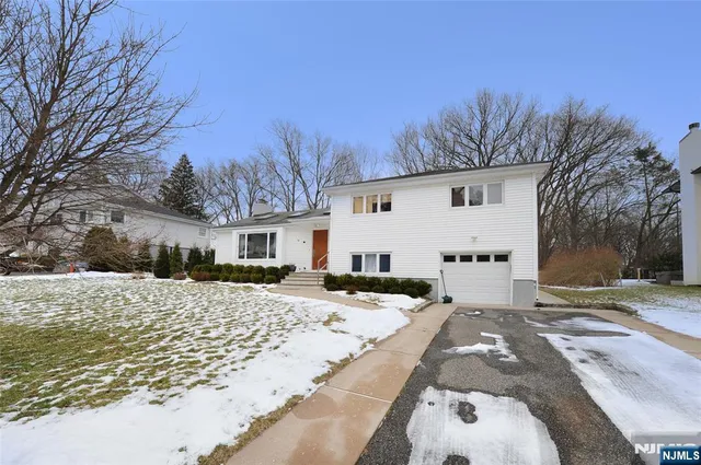 a view of a white house with a yard covered in snow