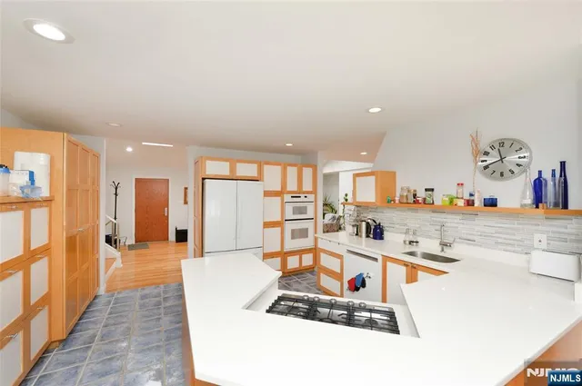 a room with stainless steel appliances kitchen island granite countertop a sink and cabinets
