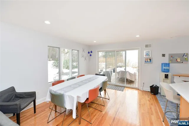 a living room with a floor to ceiling window and wooden floor