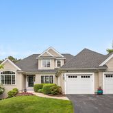 a front view of a house with a garden and garage