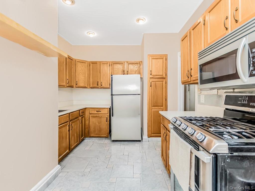 472 Gramatan Avenue, Unit O2 Mount Vernon, NY 10552 - Photo 5 of 13 a kitchen with stainless steel appliances granite countertop a refrigerator stove and sink