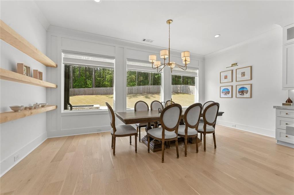 2694 Thompson Mill Road Buford, GA 30519 - Photo 32 of 70 a view of a dining room with furniture a chandelier and wooden floor