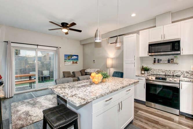 1409 Victorian Alley Sacramento, CA 95818 - Photo 3 of 45 a kitchen with granite countertop kitchen island stainless steel appliances a stove sink and refrigerator