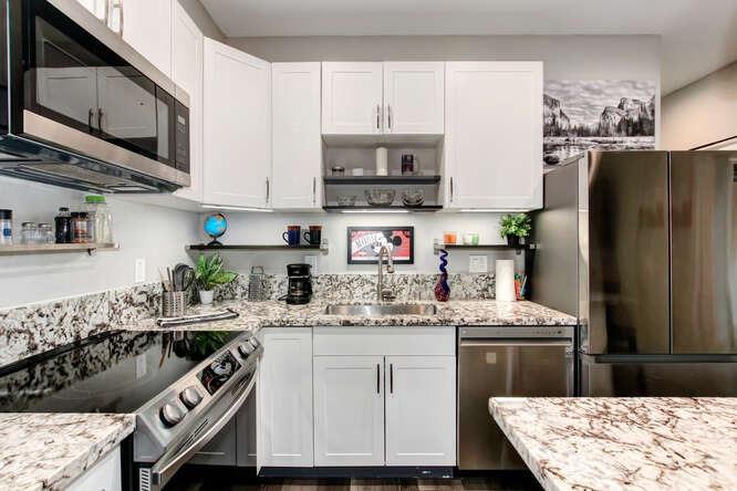 1409 Victorian Alley Sacramento, CA 95818 - Photo 5 of 45 a kitchen with stainless steel appliances granite countertop a sink stove and refrigerator