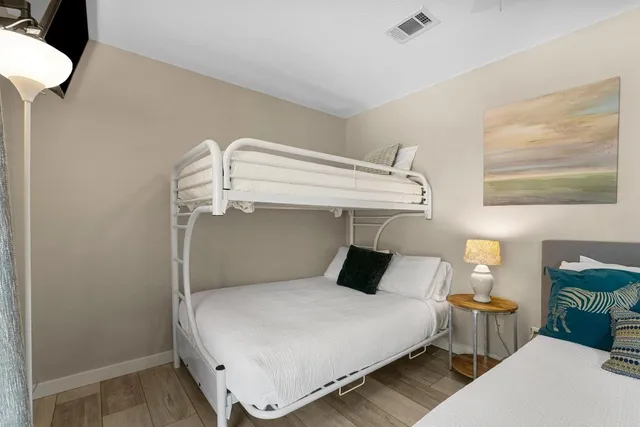 a bedroom with a bed and wooden floor