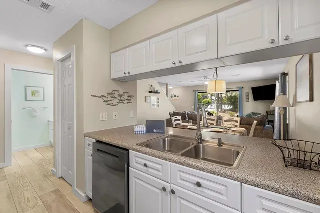 a kitchen with stainless steel appliances granite countertop a sink a stove and white cabinets