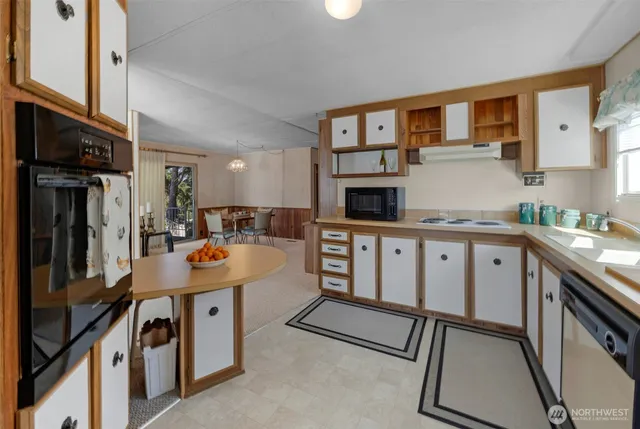 a kitchen with stainless steel appliances kitchen island a refrigerator sink and cabinets