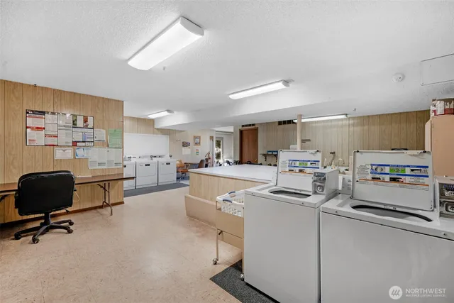a room with stainless steel appliances kitchen island a table and chairs
