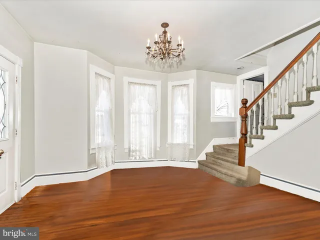 a dining room with furniture a chandelier and wooden floor