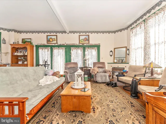 a living room with furniture a flat screen tv and a floor to ceiling window