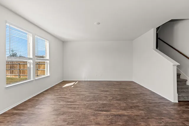 a view of a living room a kitchen with furniture and wooden floor