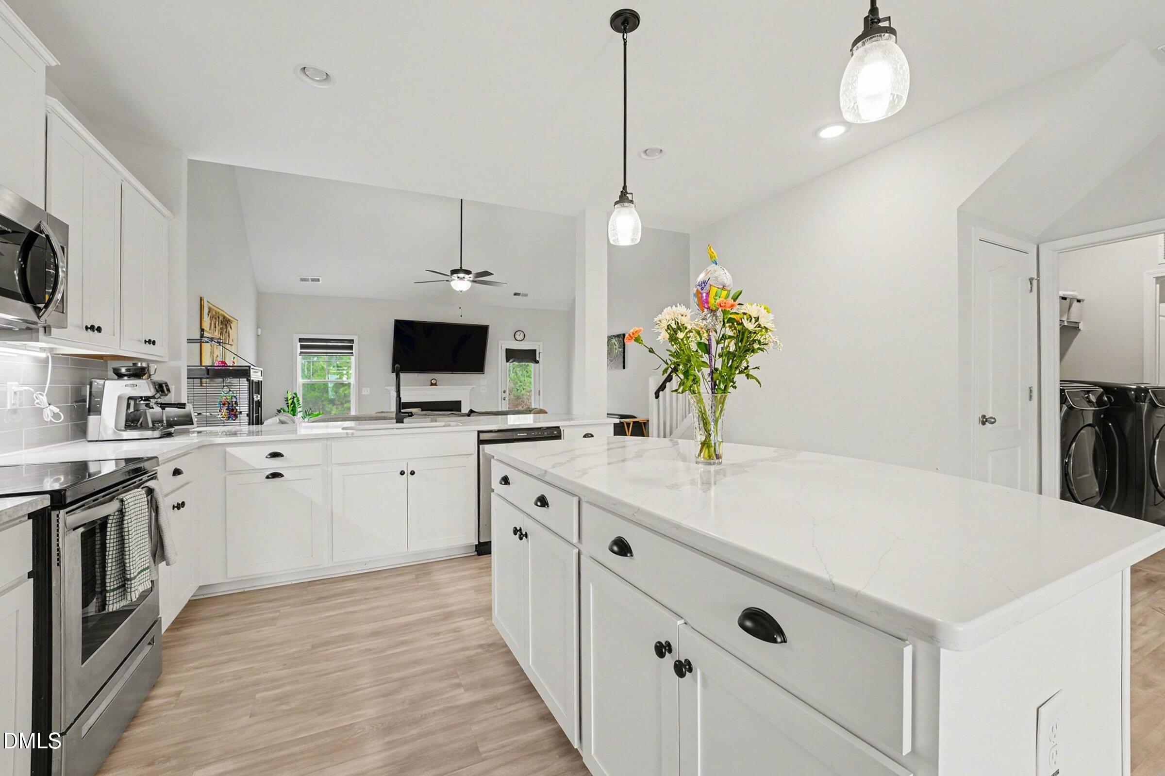 365 Timber Skip Drive Spring Lake, NC 28390 - Photo 11 of 33 a kitchen with stainless steel appliances kitchen island granite countertop a stove a sink and a refrigerator
