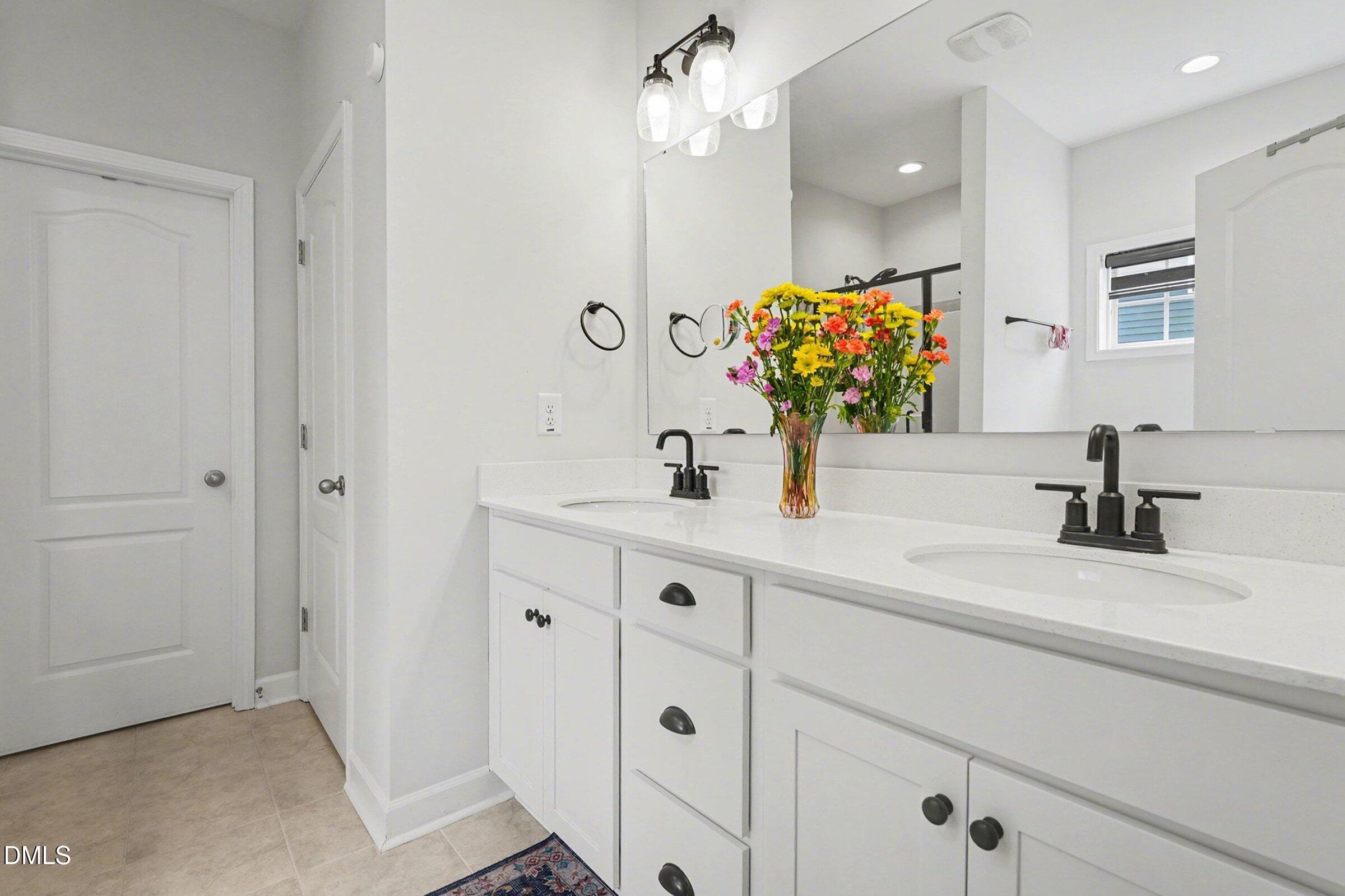 365 Timber Skip Drive Spring Lake, NC 28390 - Photo 18 of 33 a bathroom with a double vanity sink a mirror and shower