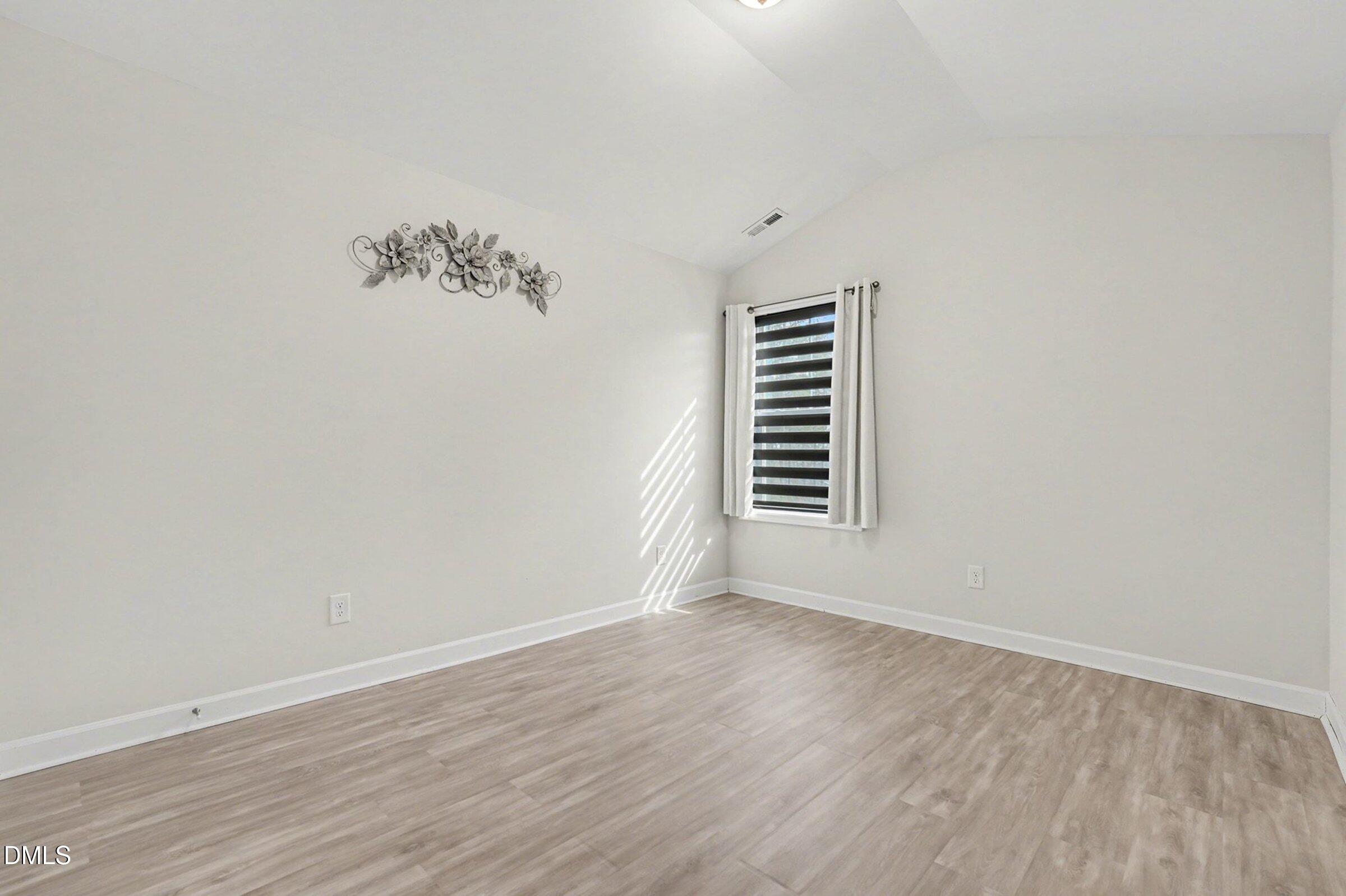 365 Timber Skip Drive Spring Lake, NC 28390 - Photo 22 of 33 an empty room with wooden floor and windows