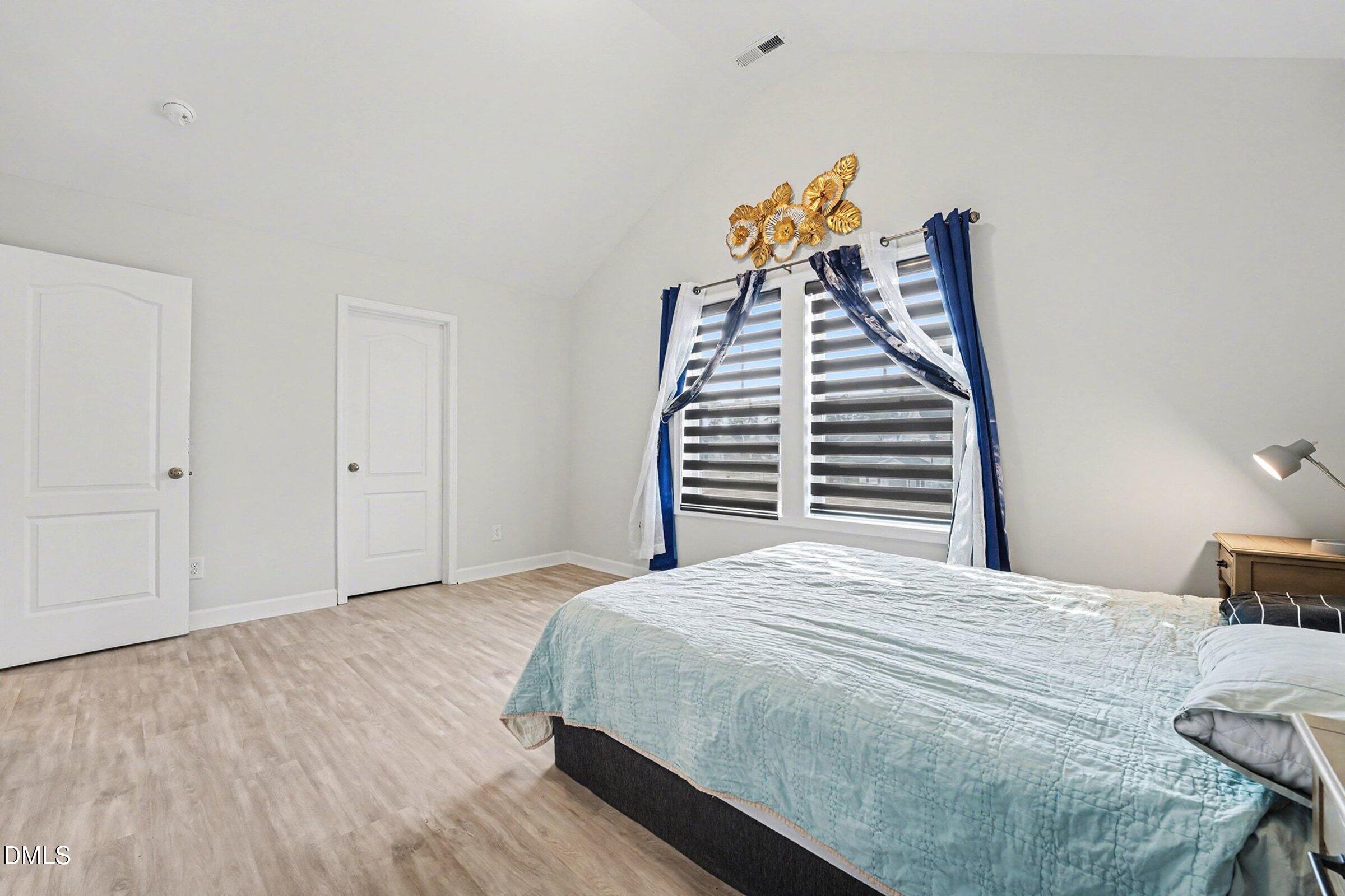 365 Timber Skip Drive Spring Lake, NC 28390 - Photo 26 of 33 a bedroom with a bed and a chandelier
