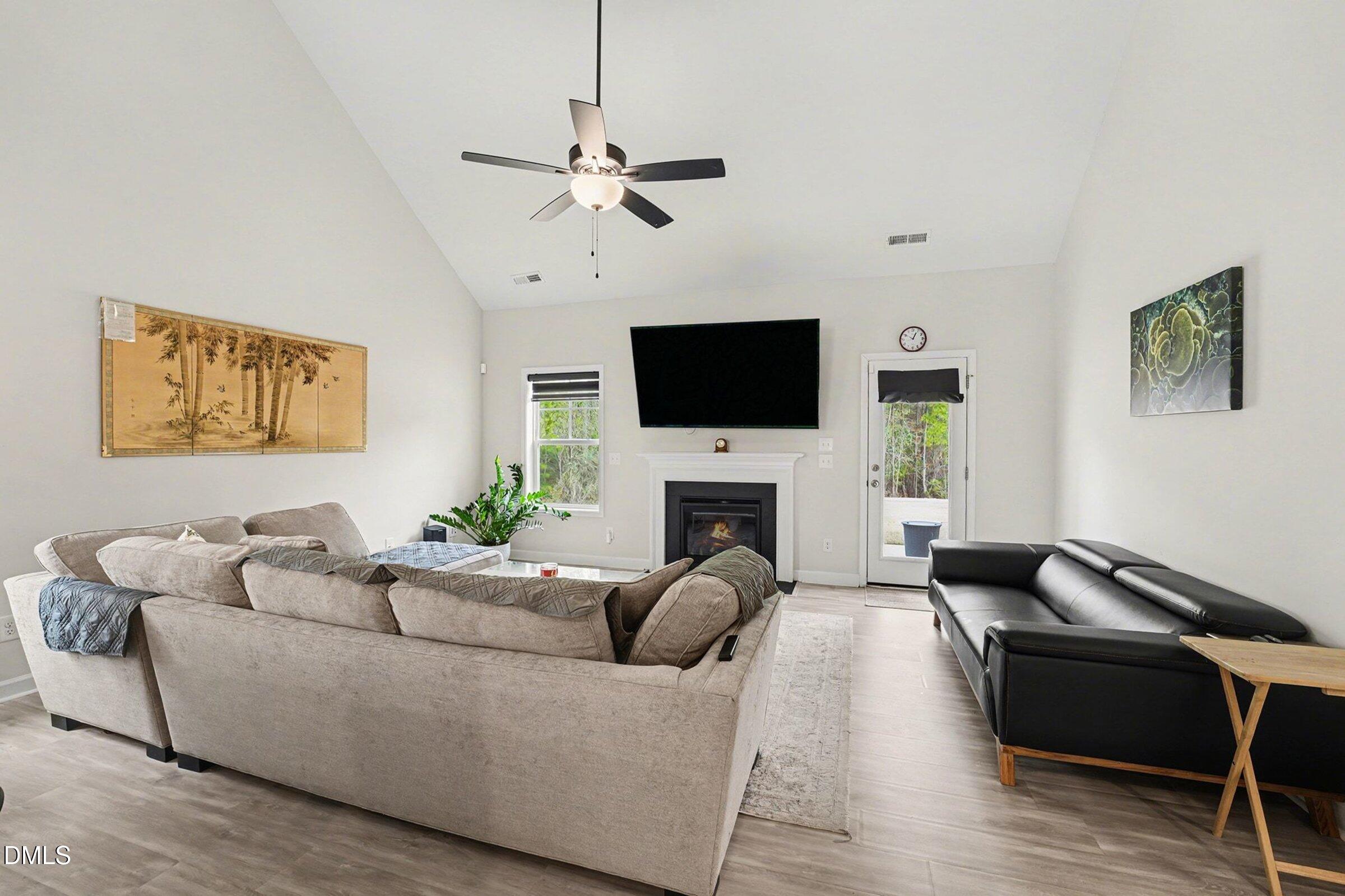 365 Timber Skip Drive Spring Lake, NC 28390 - Photo 5 of 33 a living room with furniture a fireplace and a flat screen tv