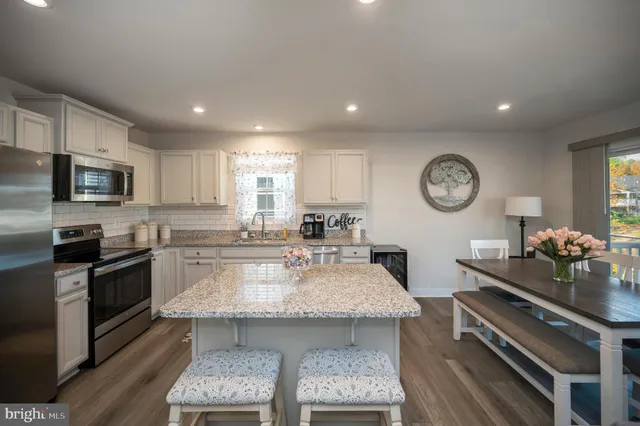 a kitchen with refrigerator a microwave a sink and cabinets
