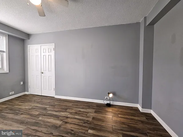 a view of empty room with wooden floor