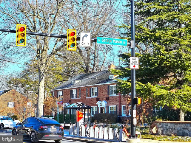 a front view of a house with large trees