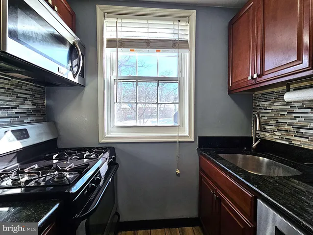 a kitchen with a sink stove top oven and cabinets